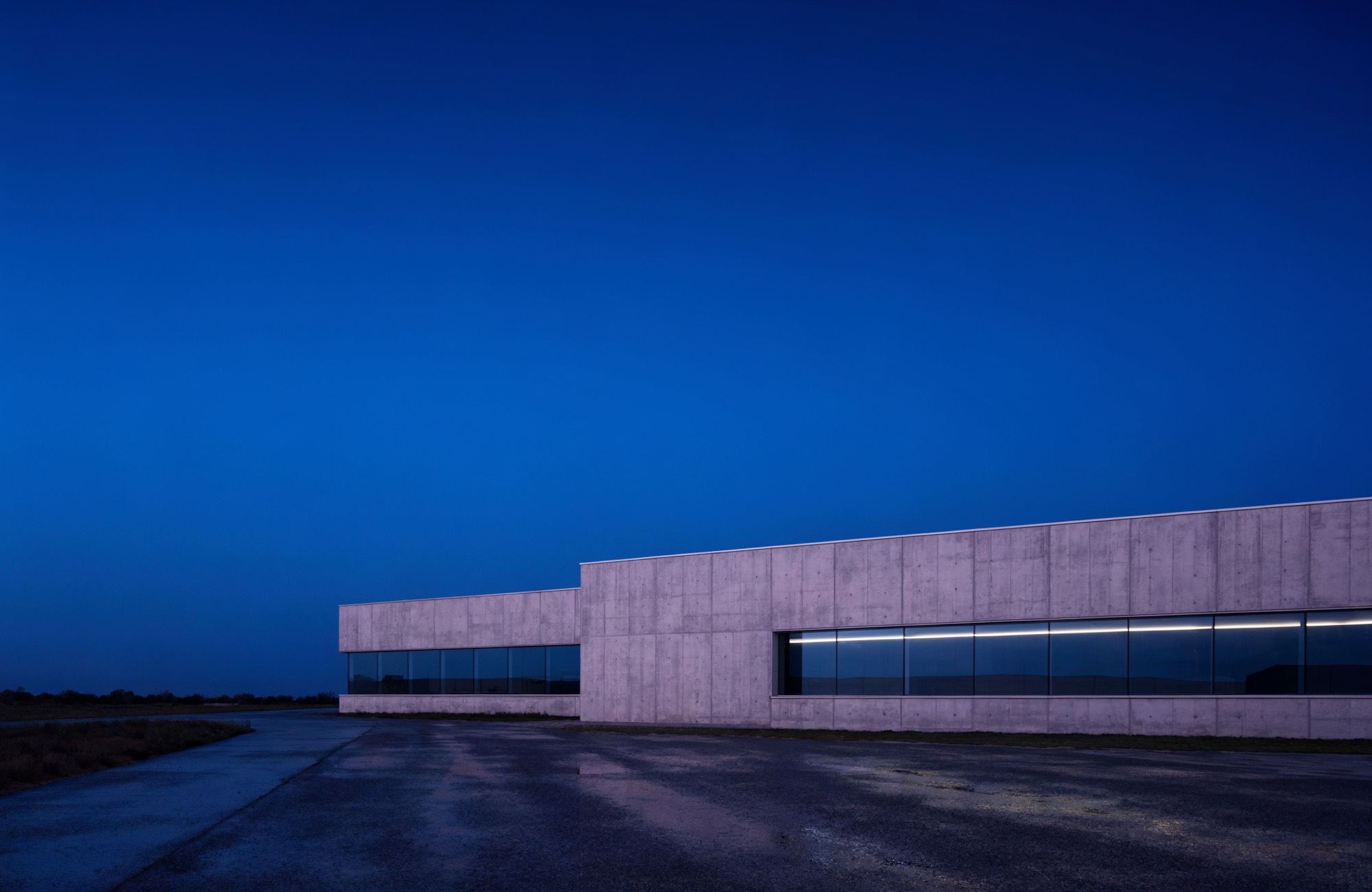 Low concrete network facility photographed at dusk
